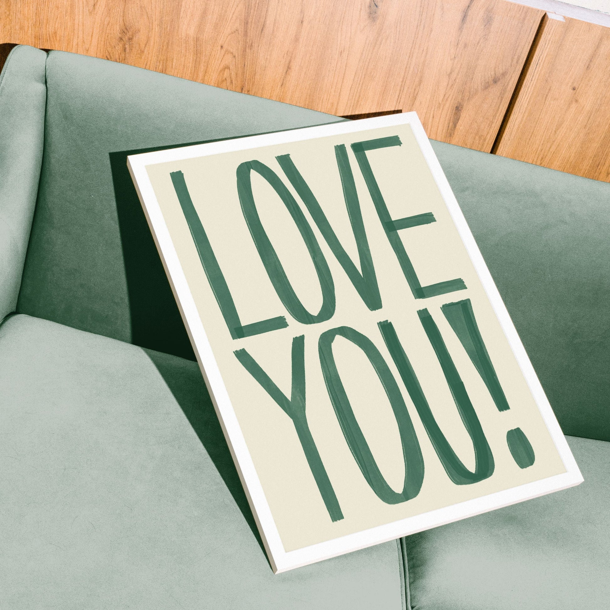 bold typography framed print saying Love You! on a retro green sofa